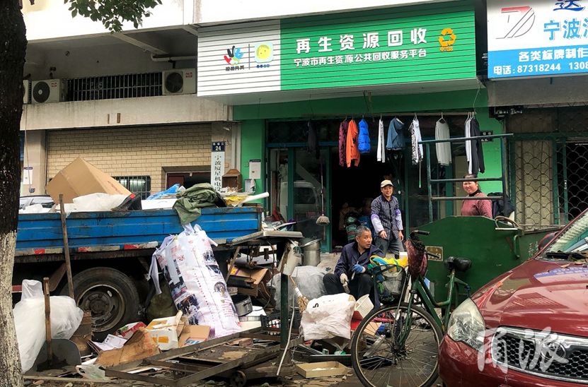 江北建业街上再生资源回收站,收废品的车辆将人行道占据.