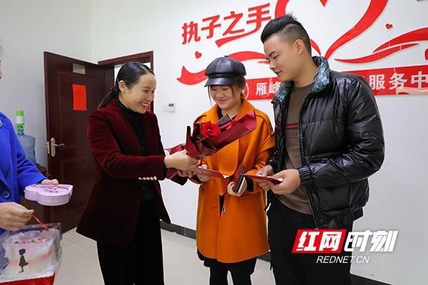 衡阳市雁峰区委副书记,区长王燕(左一)为结婚登记新人陈先生和魏女士