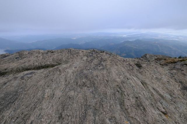 站在摩柱峰顶平坦的火山石上眺望远方.