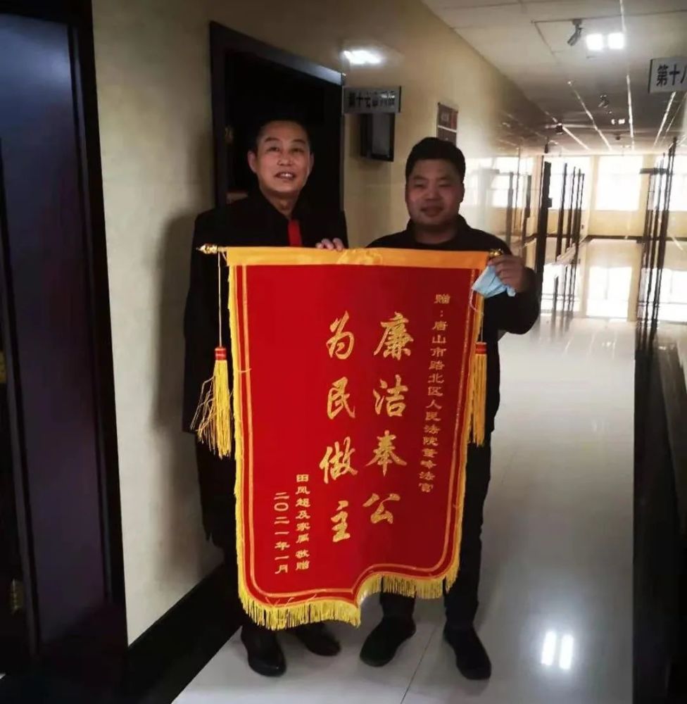 将一面绣着"廉洁奉公 为民做主"的锦旗送至路北法院董峰法官手中