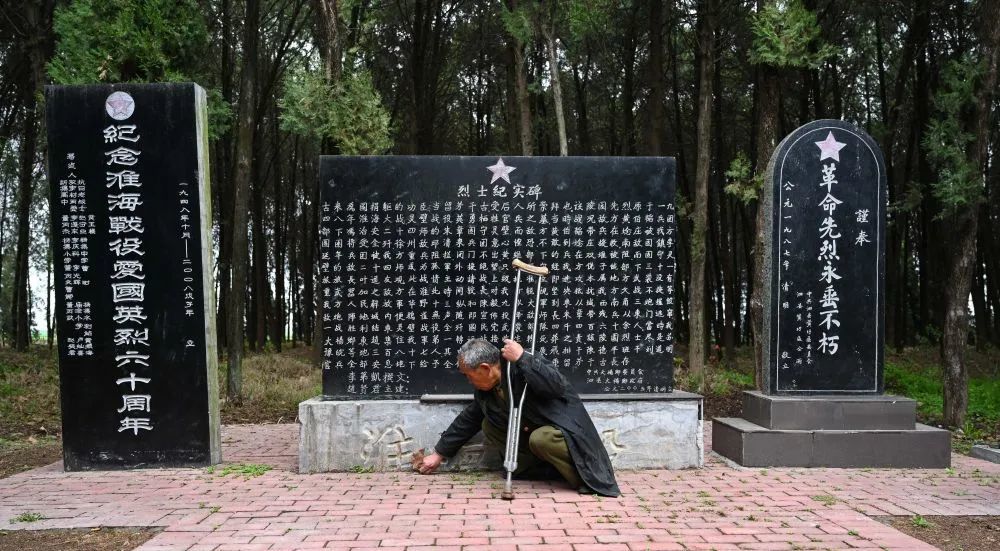 4月1日,赵贤军在泗县大杨乡东赵集烈士陵园清除墓碑前的杂草.