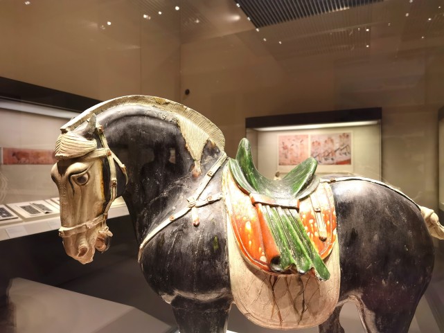 这件马俑全身黑色,唯马面,鬃尾和四蹄为白色,鞍鞯为绿,黄,白三色相间