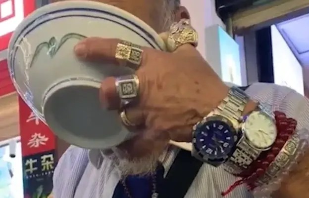 海口一老人手上戴满手表和戒指却向一女孩讨饭吃