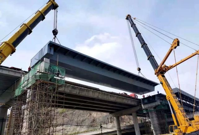图为:2021年4月25日凤凰山大桥拓宽改造工程重要工序——跨高速钢箱梁