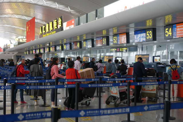 银川河东国际机场航站楼出发大厅,不少旅客正在排队值机和托运行李.