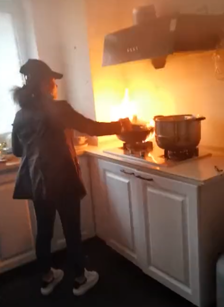 黑龙江一女子厨房做饭,结果炒锅起火了,一屋人慌了