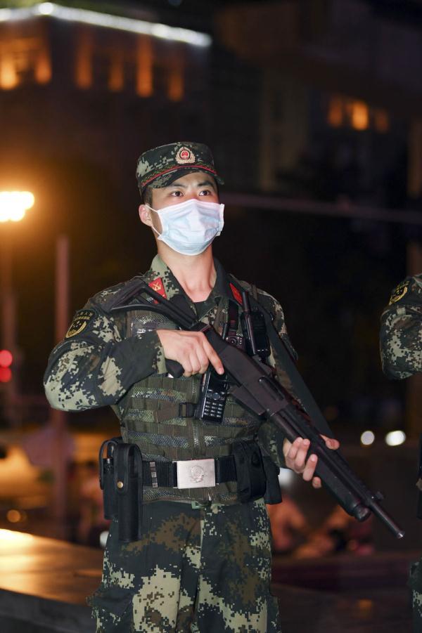 图为武警官兵在巴南万达广场人流密集处定点执勤,确保节假日期间社会