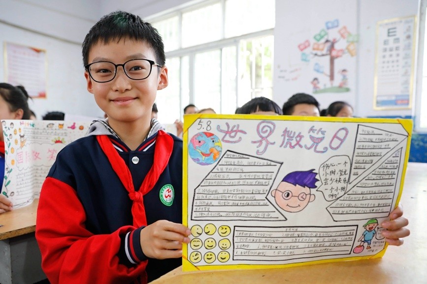 学生展示制作的"微笑日"手抄报.何五昌摄