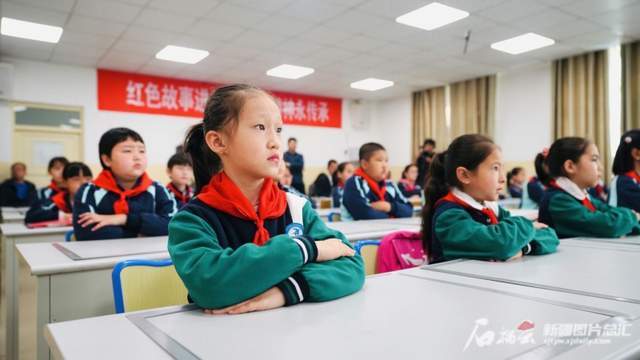 5月12日,阿合奇县团结小学学生们正在聆听孙树庭老人的故事.