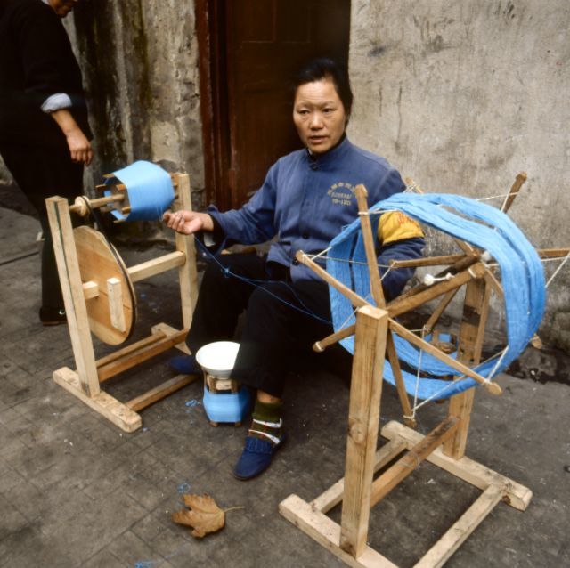 1982年中国珍贵历史老照片:图为一个纺织厂的工人在用纺车纺线.