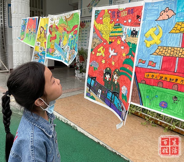 图:学生参观绘画作品童心向党,不仅在孩子们质朴的心灵里种下了一颗