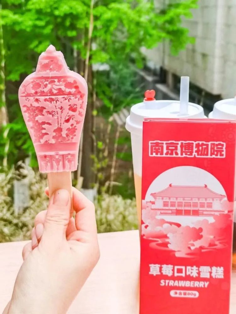 红色的花瓶状雪糕上,临摹雕刻着松,竹,梅的花纹样式,一口咬掉梅瓶盖子
