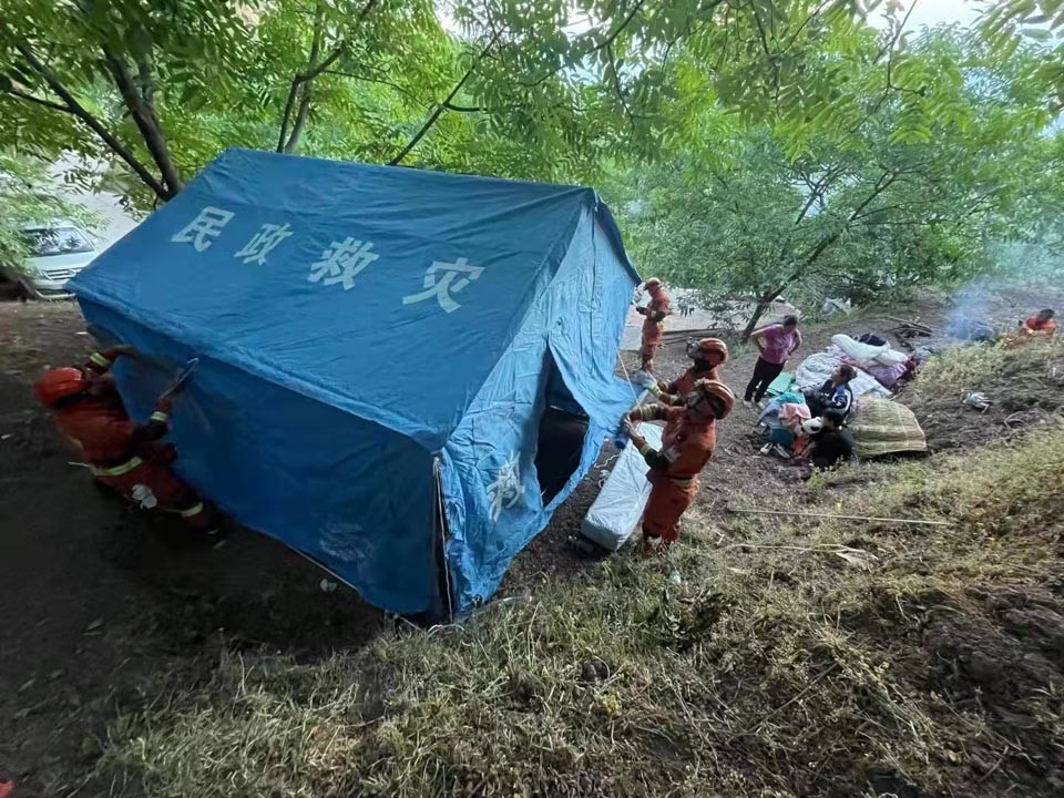 2021年5月22日,在云南漾濞地震灾区,救援人员在搭建救灾帐篷.