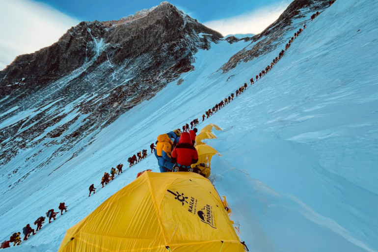 登山者在攀登珠穆朗玛峰爬坡时排成长队