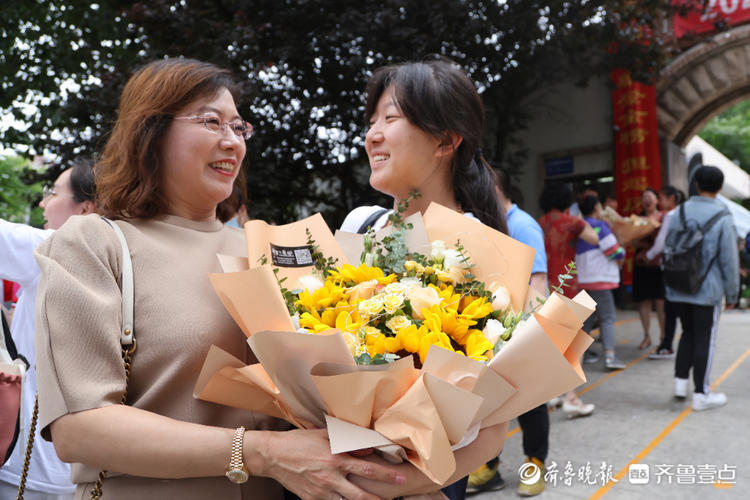 部分考生结束高考考点前手捧鲜花和老师家长合影