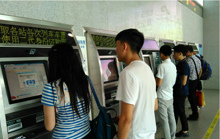 部分学生旅客在涪陵北火车站自助售取票机前办理业务