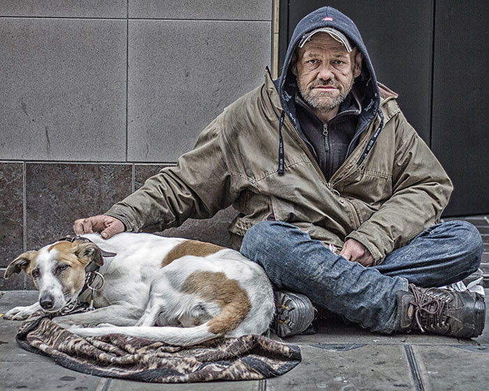 街头上无家可归的流浪汉和他忠诚的狗.