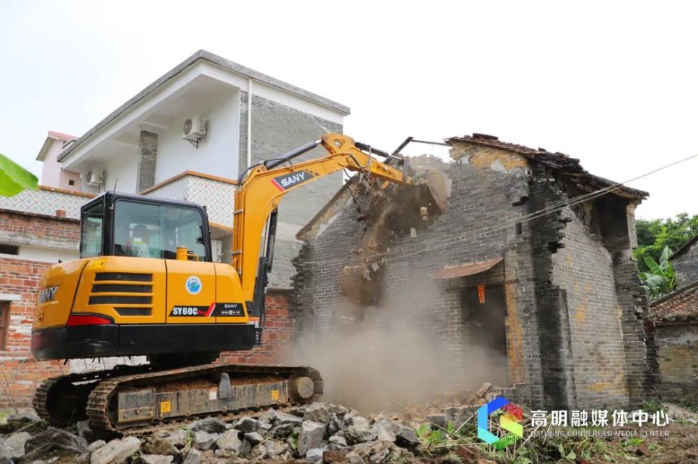 在明城镇明阳村委会朗第村,区长梁耀斌带领大家清理废旧砖瓦,挖掘机也