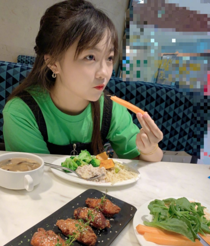 她还晒出两张自己在素食餐厅吃饭的照片,手拿胡萝卜条姿势优雅,整体看