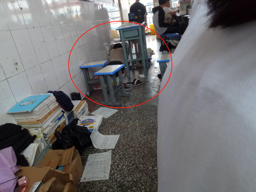 这位同学直接在教室里脱光了上衣,脱掉了鞋子,在地上铺了几张卷子纸