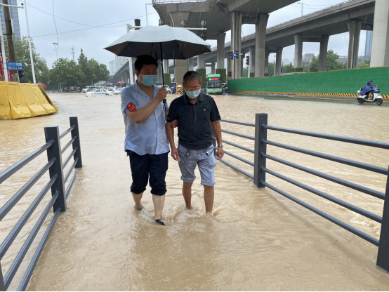 暴雨来袭志愿者雨中坚守保出行