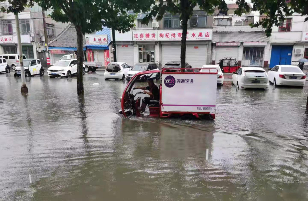 郑州快递小哥齐胸深水中推车 2小时救回2千包裹