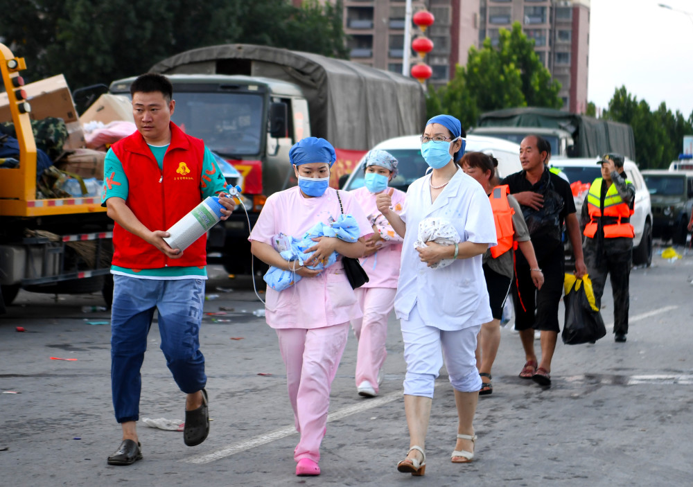 7月26日,医护人员抱着新生儿,向救护车跑去.新华社记者郝源摄