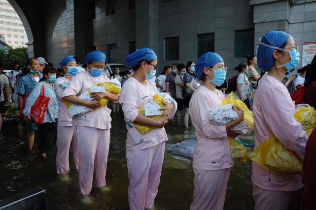 7月26日,河南新乡医学院第一附属医院,护士抱着刚出生的婴儿准备转移.