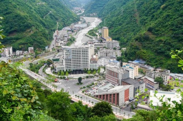 县城海拔千米左右,处在绿树环绕的大山之间,一条河流从县城中间流过