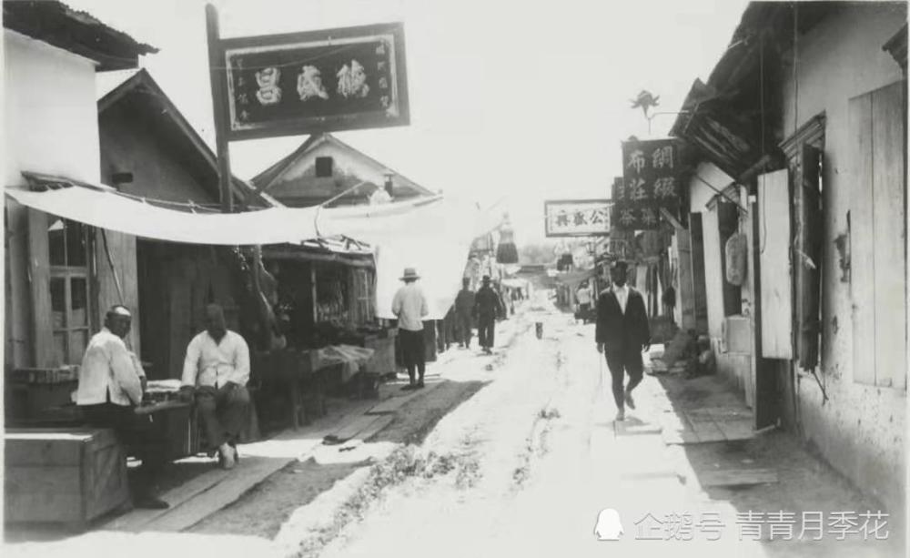 1935年,饶河县城的街道,有人穿着西服.两边有布庄等店铺.