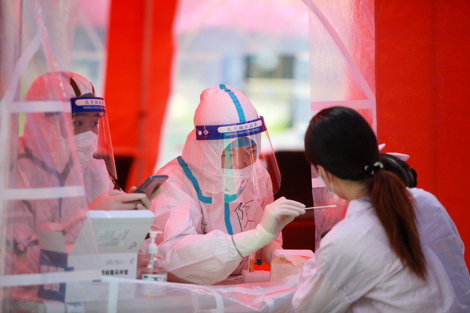 2021年8月11日,扬州邗江区竹西街道竹西社区的核酸检测点,医务人员为