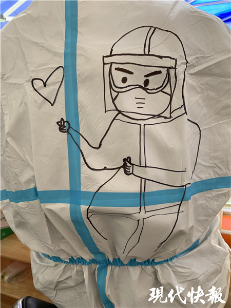 一个小朋友指着穿着防护服的医护人员说