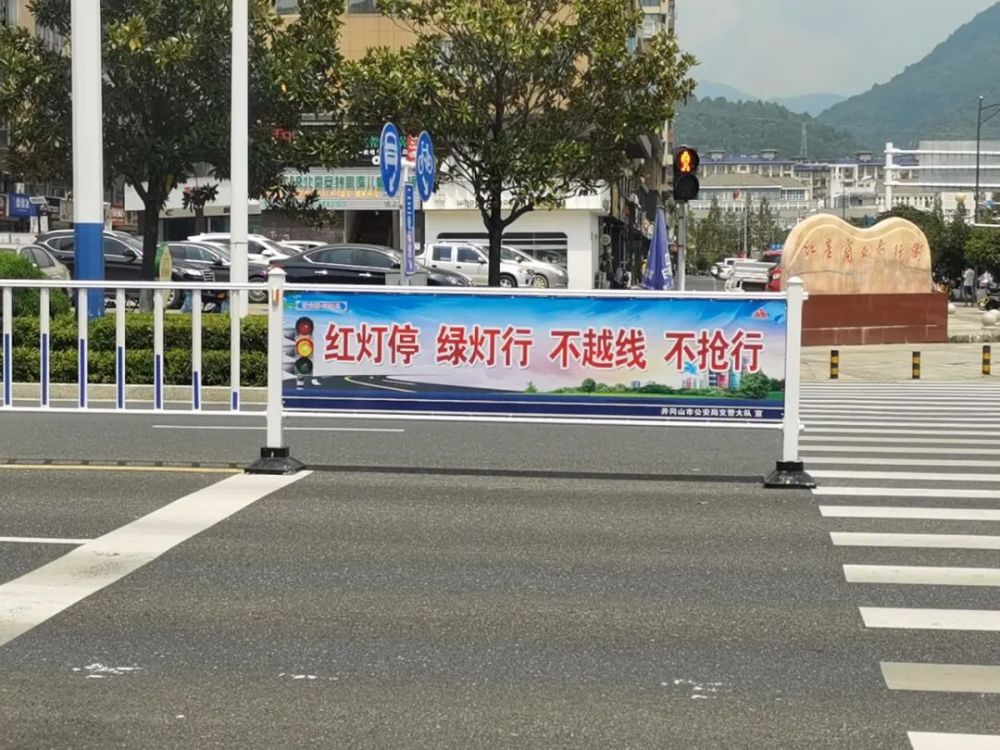 创城进行时护栏上的宣传标语是井冈山交警给您的温馨提示