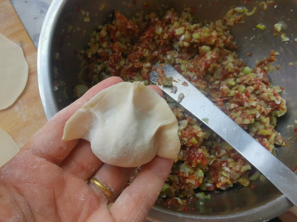 第九步:两只手捏紧,饺子就完成了,重复包饺子的步骤,把所有饺子包完
