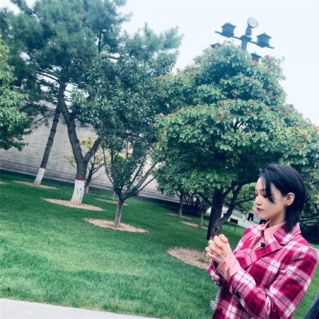 张馨予晒景区游客照,身穿红格纹套装干练十足,手上