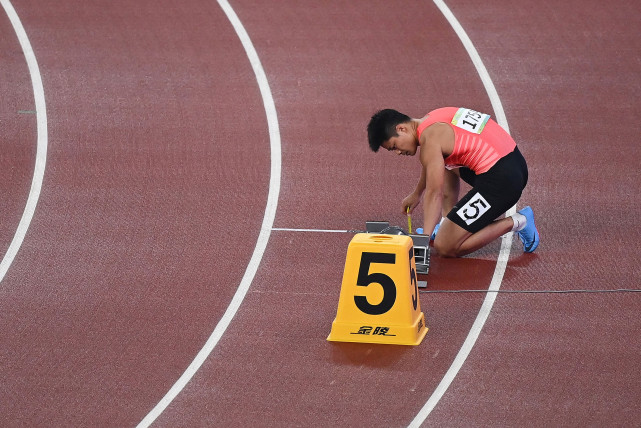 9月23日,广东队第一棒选手苏炳添在赛前测量起跑器.广东队获得亚军.