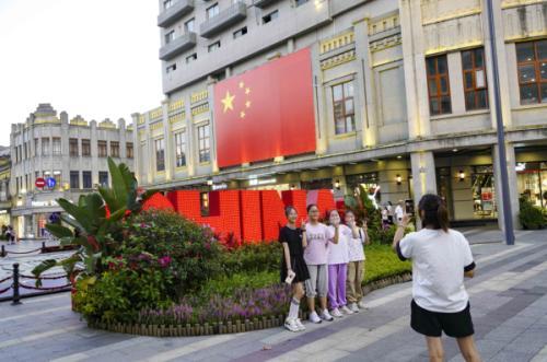 温州网讯 9月25日,在温州市区五马街,市民在巨型国旗前留影.