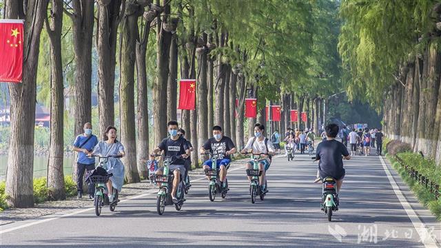 武汉东湖绿道:游客着红装骑行,享受初秋自然美景