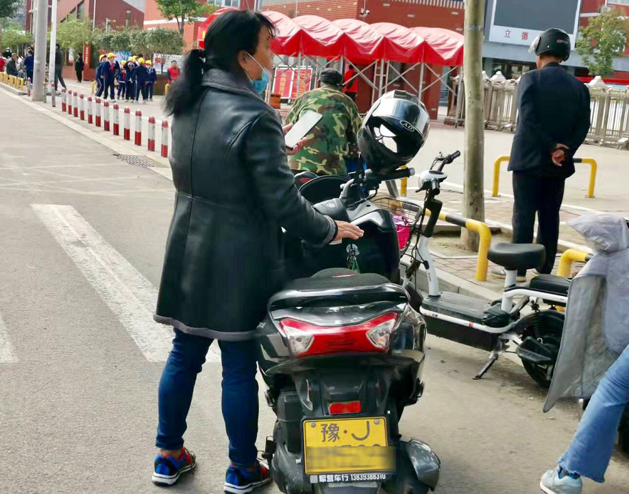 市民正在给自己的电动车安装牌照