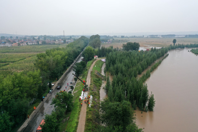 10月11日,抢险人员在汾河下游稷山段下迪河坝段加固堤坝(无人机照片.