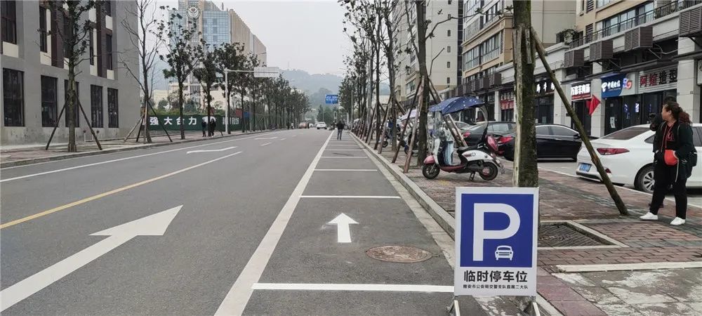 施工工人们正在道路上用卷尺量尺寸进而施划临时停车位