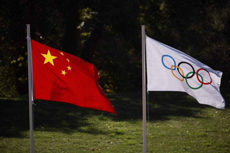 五星红旗和奥运五环旗在北京冬奥会圣火采集仪式上迎风招展.