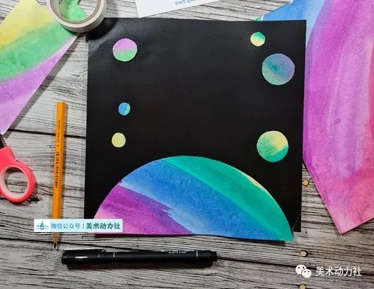 将制作好的星球错落的粘贴在黑色背景卡纸上.