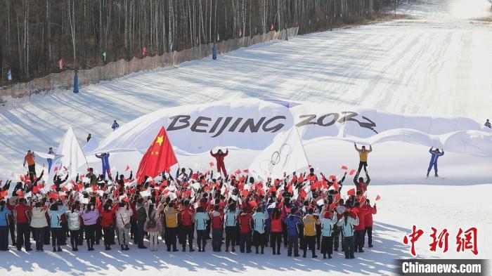 300多名冰雪运动爱好者托举起巨幅2022年北京冬奥会会旗. 邵天李 摄