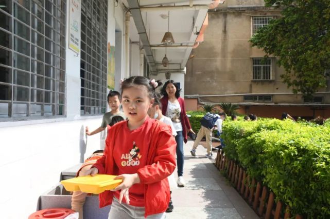 将装有餐盒和汤的保温箱为师生配送午餐的餐车驶进筱塘小学上午10时30