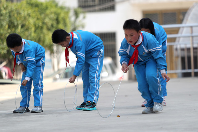 11月1日,在江西省抚州市东乡区杨桥殿镇中心小学,学生在玩滚铁环游戏