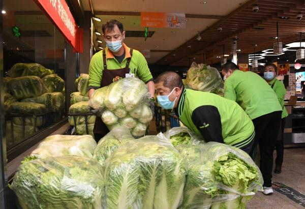 11月2日,在超市发双榆树店,工作人员在码放大白菜.