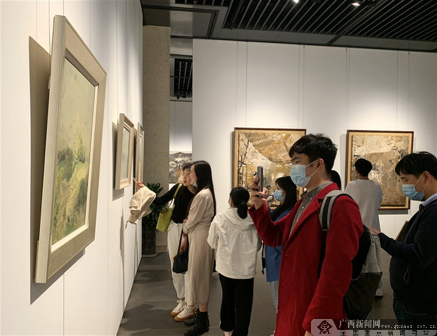热爱绘画的观众在广西书画院观看油画展.