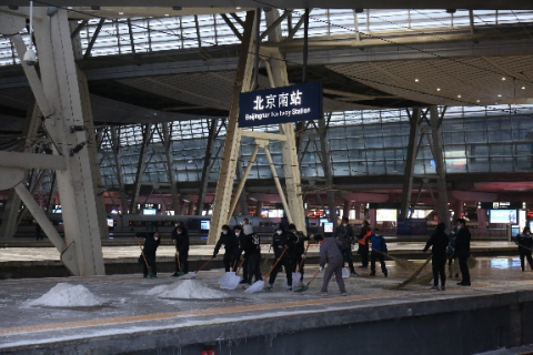 北京南站工作人员正在清扫站台积雪