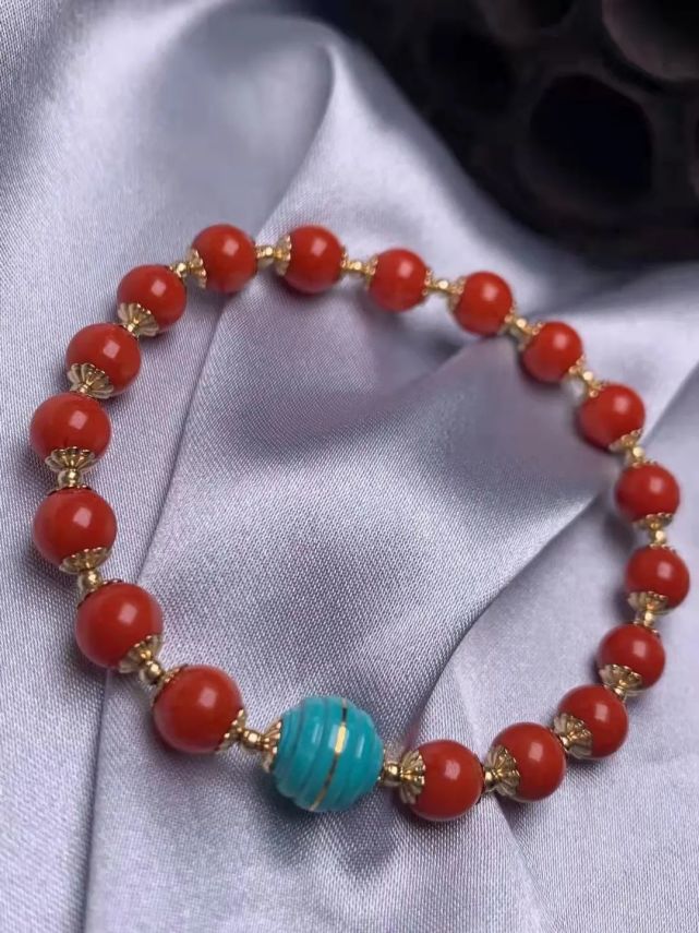 身着玄色旗袍,颈项间一串顶级红珊瑚圆珠项链,耳上佩戴红珊瑚耳饰